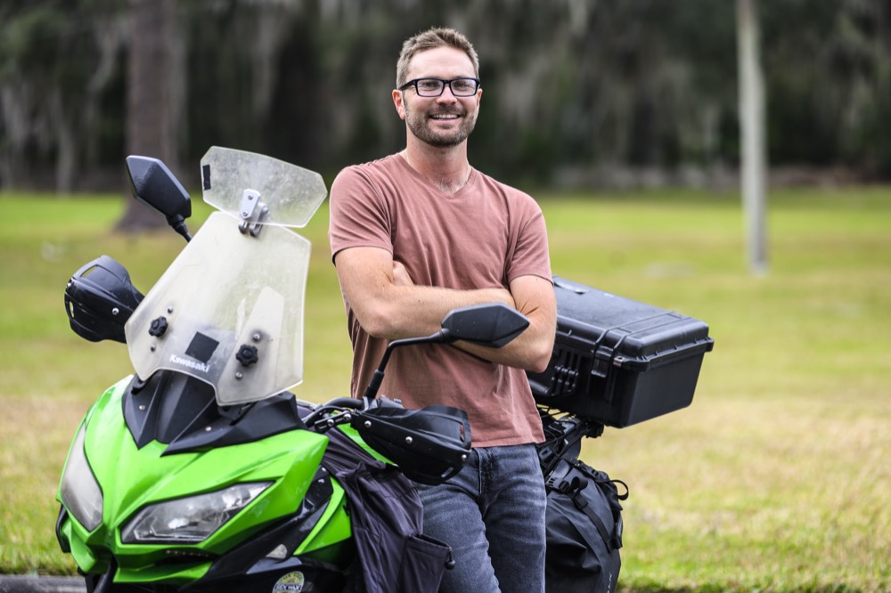 Zach Janik, ebike safety class instructor, leaning on his motorcycle and smiling